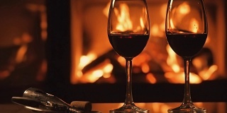 Cinemagraph -两个红酒酒杯在壁炉的背景。