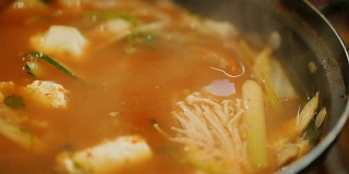 从海鲜勺中倒入热汤。正宗的韩国菜