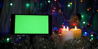 以新年为背景，绿色屏幕的智能手机。照相机围绕物体的运动。