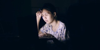亚洲女性在就寝时间坐在客厅里使用笔记本电脑