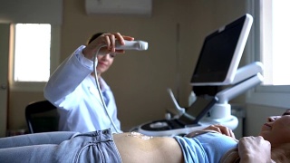 医生将凝胶放在病人的胃上进行超声检查视频素材模板下载