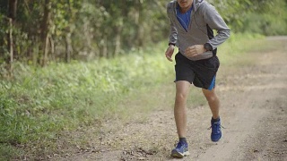 亚洲男人在开始跑步前系上运动鞋视频素材模板下载