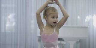 在芭蕾课上练习如何转身的举手女孩的肖像