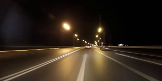 POV时间推移，快速的汽车在晚上行驶在古老的乡村道路上。迎面而来的卡车。在高速公路上行驶在古老的道路上。摄像机被放置在汽车外面，水平是水平的，给人一种穿越无尽系列的幻觉