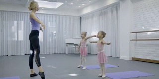 儿童舞蹈学校的老师在演播室展示女孩们的练习