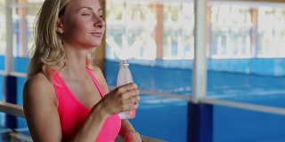 疲惫的运动女性在健身房喝水