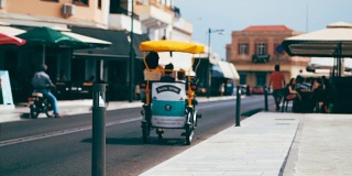 三轮车在这个欧洲度假小镇的道路上穿梭于汽车和摩托车之间