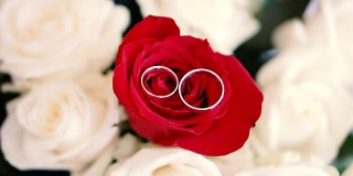 结婚戒指戴在玫瑰花束上。新婚夫妇的珠宝。婚礼配件