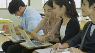 亚洲大学生正在课堂上讨论和使用笔记本电脑视频素材模板下载