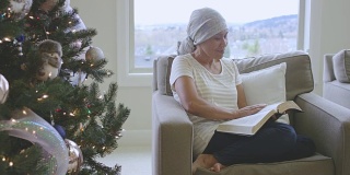 成年癌症患者在圣诞树旁阅读圣经