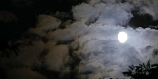 满月穿过夜空中的云。间隔拍摄