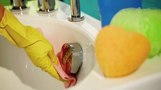 手戴手套，用抹布擦拭浴缸，打扫浴室视频素材模板下载