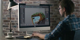 电子游戏设计师在他的个人电脑上创造一个全新的3D水平。他在一个创造性的办公环境中作为一个开发人员工作。