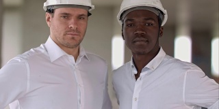 两名工程师，一名白人和一名非裔美国人，正对着镜头摆姿势