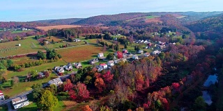 在宾夕法尼亚州波科诺斯小镇肯克尔敦的路上俯瞰，秋天的树叶。空中无人机视频。