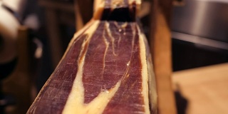 Jamon塞拉诺。传统西班牙火腿在市场上收市。桌上的猪腿火腿。餐厅内部的美食肉。整个火腿放在架子上。多莉