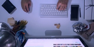 使用电脑的人。从键盘和手的顶部查看。