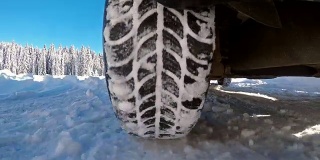 在冬天的乡村道路上开车，把雪喷到相机上