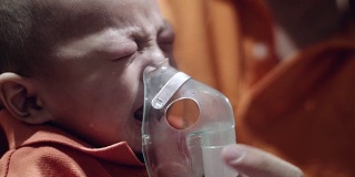 生病的孩子通过喷雾器呼吸