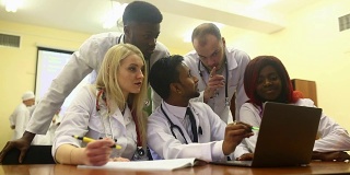 多种族的年轻医生团队在医疗办公室的笔记本电脑上工作