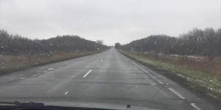 糟糕的柏油路车行驶在下雨的秋天孤独的道路上，慢镜头拍摄户外