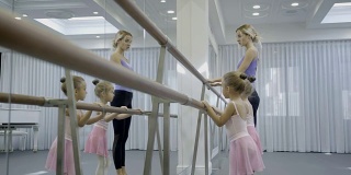 可爱的女孩和老师在芭蕾舞工作室练习
