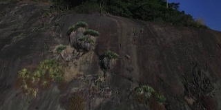 在巴西里约热内卢，攀爬岩面，露出大海