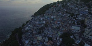 Favela Aerials:巴西里约热内卢，一个以大海为背景的山顶Favela全景照片