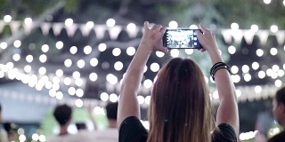 女人用智能手机在晚上的婚礼上拍照