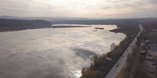 鸟瞰图卡车和汽车行驶在郊区道路上的河流背景