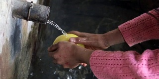 Cute Girl Washing Yellow Apple