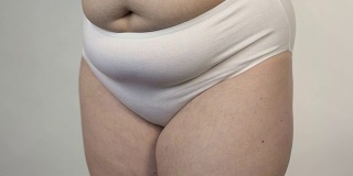 臀部的脂肪团，在镜头前摆姿势的超重女人，肥胖