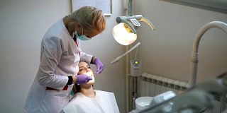 在牙科诊所接受牙科治疗的美女病人。看牙医的女人