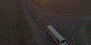 卡车在阳光明媚的傍晚行驶在公路上。鸟瞰图。相机向下倾斜。
