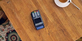 在NFC支付过程中从上面看到的咖啡杯和智能手机。