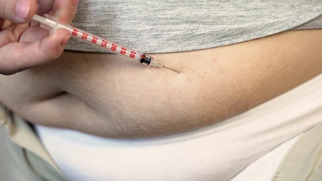 特写超重女性注射胰岛素到胃部，糖尿病