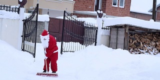圣诞老人在冬天清扫马路上的积雪，清扫马路上的风雪