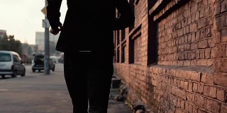 慢镜头运动员沿着老街跑步。年轻自由意志专业跑步者晨训。后视图