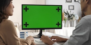 两个人用电脑，对着绿屏说话，色度键