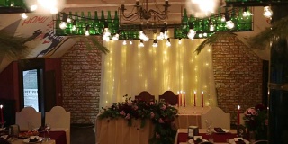 圣诞婚礼宴会厅的室内细节与餐厅的装饰和餐桌设置汇编。冬季装饰的球根花环，蜡烛，鲜花，球果和冷杉树枝
