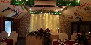 圣诞婚礼宴会厅内部装饰和餐桌设置的广角拍摄。冬季装饰的球根花环，蜡烛，鲜花，球果和冷杉树枝