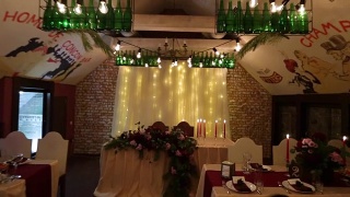 圣诞婚礼宴会厅内部装饰和餐桌设置的广角拍摄。冬季装饰的球根花环，蜡烛，鲜花，球果和冷杉树枝视频素材模板下载