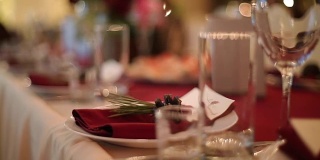 圣诞婚礼宴会厅内部细节装饰和餐桌设置在餐厅。冬季装饰的球根花环，蜡烛，鲜花，球果和冷杉树枝