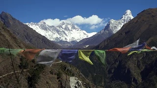 在尼泊尔喜马拉雅山脉的珠穆朗玛峰地区，西藏的经幡在白雪皑皑的山顶上飘扬视频素材模板下载