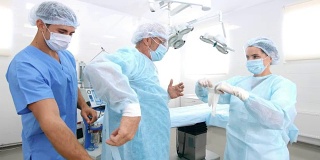 护士和助理在手术室给手术服敷料