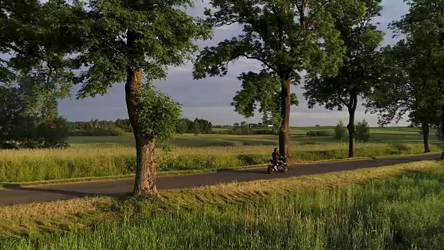 骑摩托车旅行。日落时的乡村景观