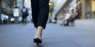 女人的脚在市中心行走的特写镜头。穿着高跟鞋的女商人。慢动作