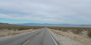 在沙漠山谷的空旷道路上驾驶拍摄，4K慢镜头