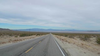 在沙漠山谷的空旷道路上驾驶拍摄，4K慢镜头视频素材模板下载