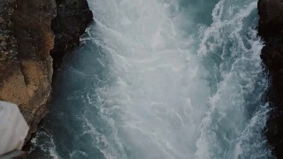 俯瞰汹涌的蓝色水流流过岩石。山川美景视频素材模板下载